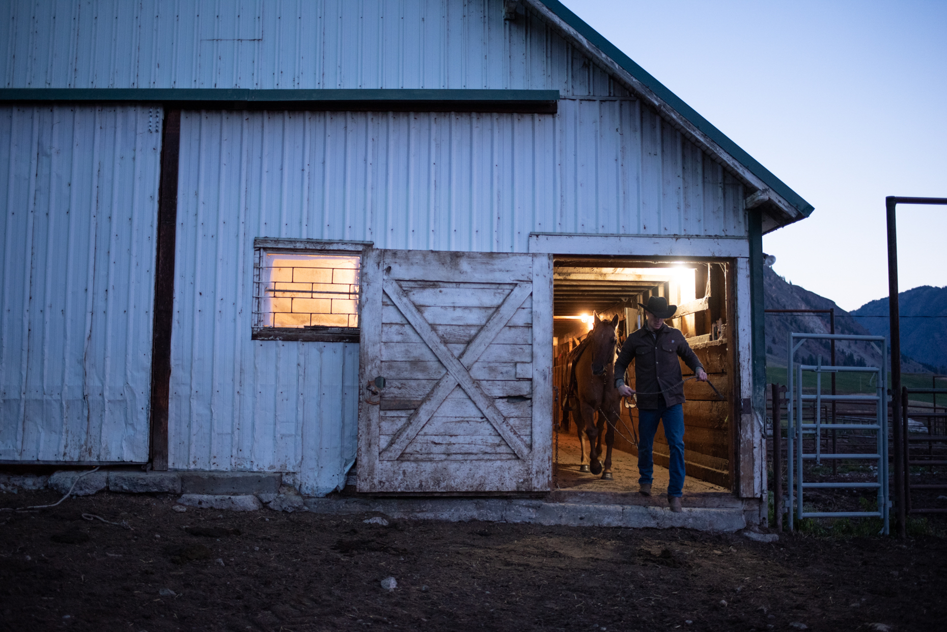 Cowboy and horse leaving barn before sunrise on a northern Washington cattle ranch. Isaac Miller Photography  | Agriculture & Industry Photographer  |  Commercial & Editorial photography  |   Missoula + San Antonio